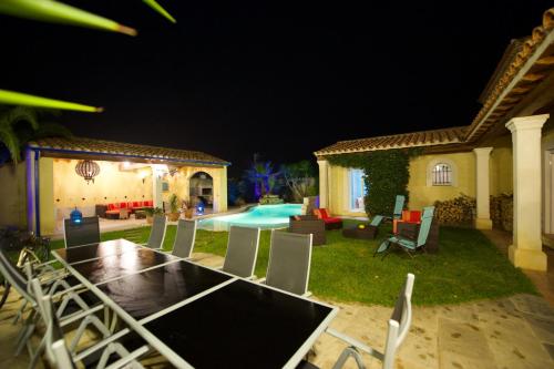 ヴィック・ラ・ガルディオルにあるLa hacienda - Villa 6 Chambres Piscine, Plage à 5mnの裏庭(テーブル、椅子付)、プールを提供しています。