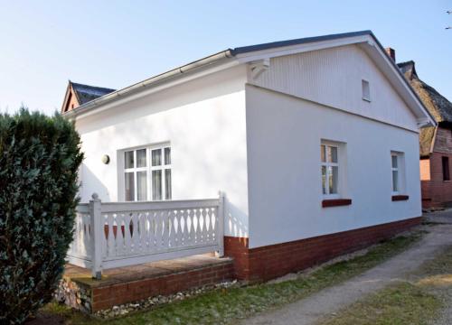 une maison blanche avec une clôture blanche dans l'établissement Ferienwohnungen Fiete _ Ole, à Sellin