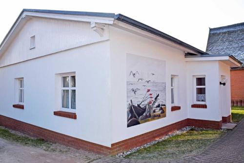 une peinture murale sur le côté d'un bâtiment blanc dans l'établissement Ferienwohnungen Fiete _ Ole, à Sellin