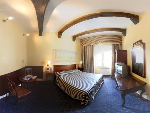 カッシーノにあるHotel La Pace - Experienceのベッドとテレビが備わるホテルルームです。
