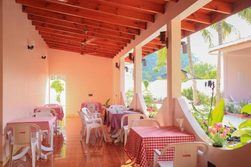 a restaurant with tables and chairs on a patio at Evila Inn - Thoddoo in Thoddoo