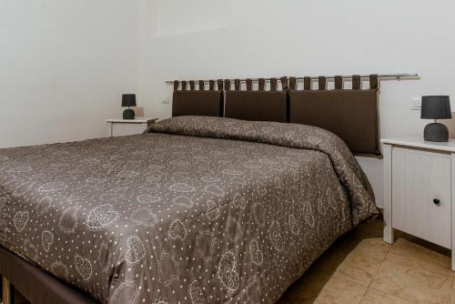 アルベロベッロにあるア ドゥエ パッシ ダル セントロのベッドルーム1室(ベッド1台、ブラウンの掛け布団付)