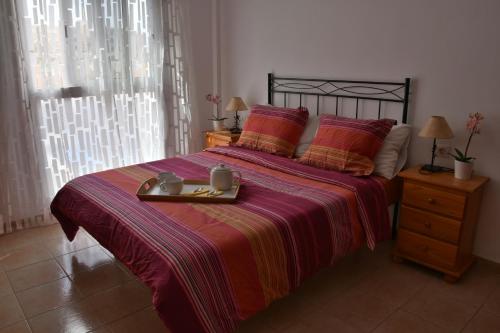エル・メダノにあるEl Medano Playa del Cabezoのベッドルーム1室(ベッド1台、食料品のトレイ付)