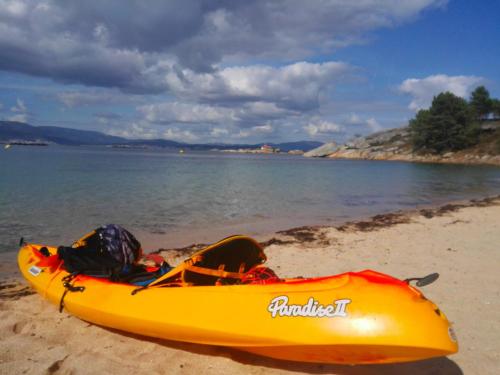 a yellow kayak sitting on a beach next to the water at Casa Guillan Illa de Arousa in Isla de Arosa