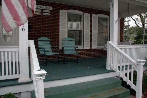 a porch with a porch chair and a blue and white fire hydrant at Maria's Garden & Inn in Berkeley Springs