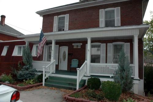 a red brick house with a flag on the front porch at Maria's Garden & Inn in Berkeley Springs