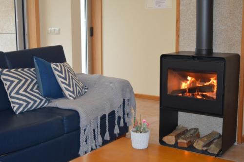 a living room with a couch and a fireplace at Casinhas do Gerês in Geres