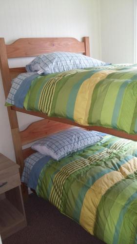 two beds sitting next to each other in a room at Departamentos Arlenne in Valdivia