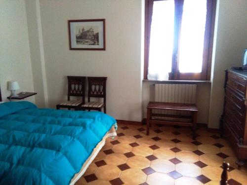 a bedroom with a bed and two chairs and a window at Il Vigneto in Trecastagni