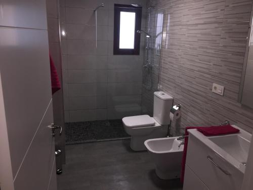 een badkamer met een toilet, een douche en een wastafel bij Playa Granada Golf in Motril