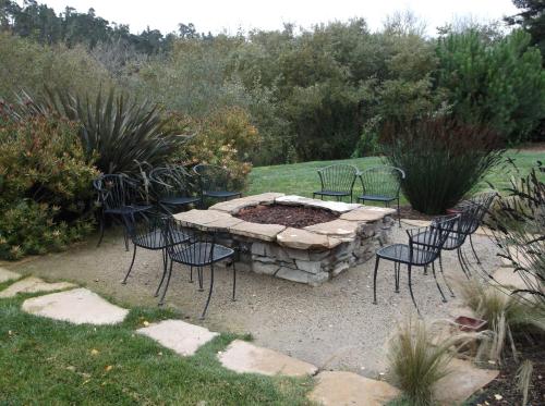 a group of chairs around a fire pit in a yard at Cambria Palms Motel in Cambria