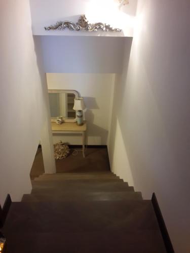 a stairway with a mirror and a table with a lamp at B&B L'Orologio in Signa