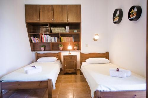 two twin beds in a room with a book shelf at Villa Jasmin in Koxaré