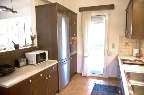 a kitchen with a stainless steel refrigerator and a microwave at Villa Jasmin in Koxaré