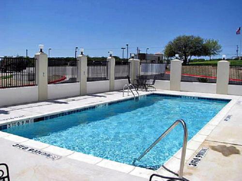 una piscina de agua azul frente a una valla en Motel 6-Marble Falls, TX, en Marble Falls