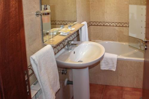 a bathroom with a sink and a bath tub at Quinta Dos Amarelos no Meco in Aldeia do Meco