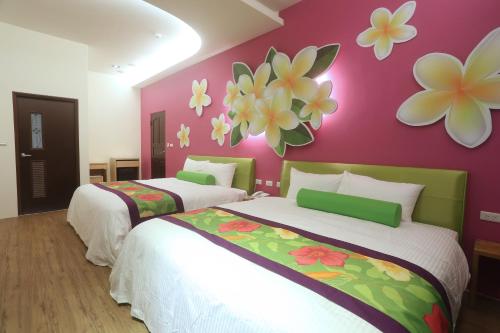 two beds in a room with flowers on the wall at Teamilu Homestay in Datong