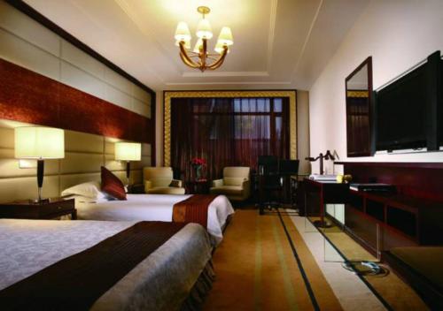 a hotel room with a bed and a desk at Dunhuang Hotel in Dunhuang