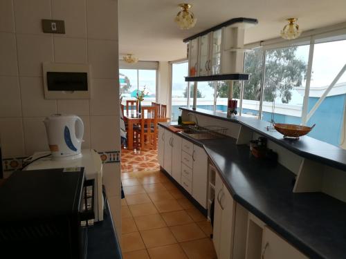 cocina con encimeras negras y vistas al océano en Condominio Altos de Mirasol II, en Algarrobo
