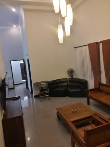 a living room with a black couch and a table at Banyu Homestay in Banyuwangi