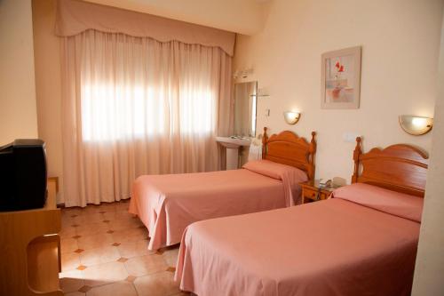 Postel nebo postele na pokoji v ubytování Hostal París