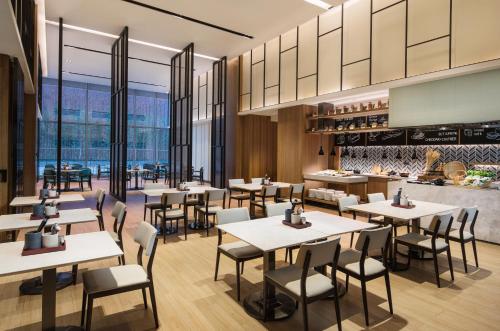 a restaurant with tables and chairs and a counter at Fairfield by Marriott Dongguan Changping in Dongguan