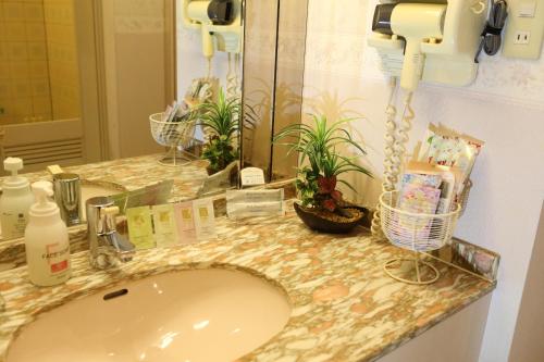 encimera con lavabo y espejo en Hotel La Siena (Adult Only), en Higashiōsaka