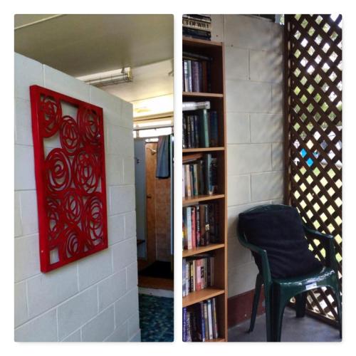 a room with a chair and a book shelf with books at Rose City Caravan Park in Warwick