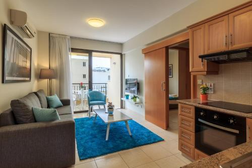 a kitchen and living room with a couch and a table at SOHO City Apartments in Larnaca