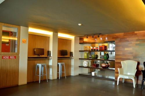 a living room with white chairs and a tv at Vivo Hotel in Kuantan