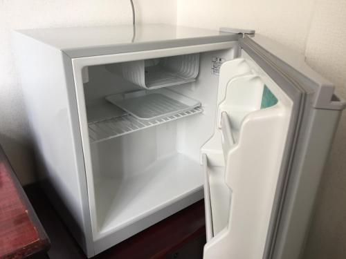 an empty refrigerator with its door open with the door open at Green Hill Hotel Tennoji Ekimae in Osaka