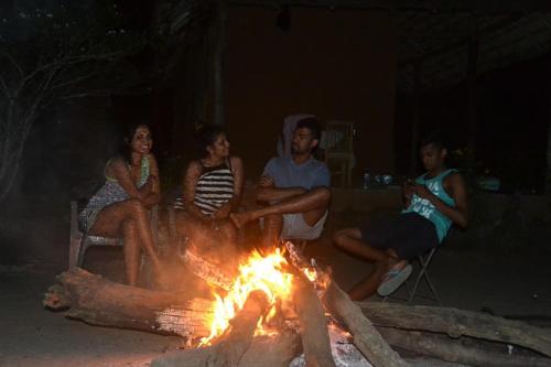 a group of people sitting around a fire at Sahana Retreat in Buttala