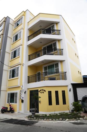 a building with a motorcycle parked in front of it at Ding Dong Homestay in Hengchun