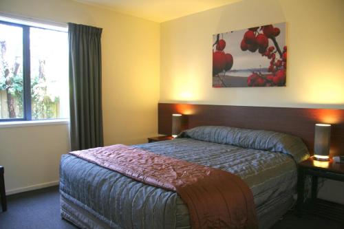 a hotel room with a bed and a window at Sherborne Motor Lodge in Christchurch