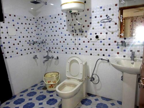 a bathroom with a toilet and a sink at Hotel Ash Vale in Srinagar
