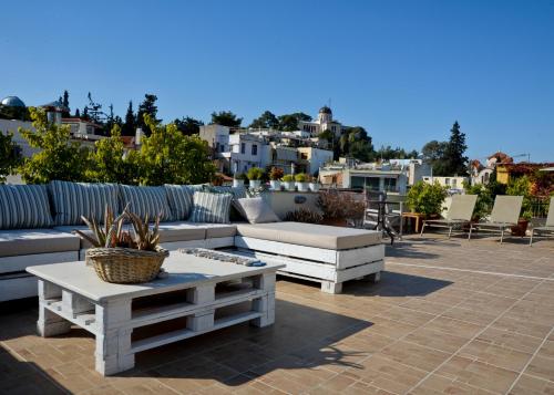 een patio met banken en een tafel en stoelen bij Meros - Athenian Residencies in Athene