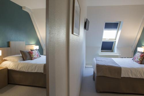 a hotel room with two beds and a window at Logis Hôtel Chaptal, Amboise in Amboise