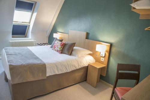 a bedroom with a bed and two lamps and a chair at Logis Hôtel Chaptal, Amboise in Amboise