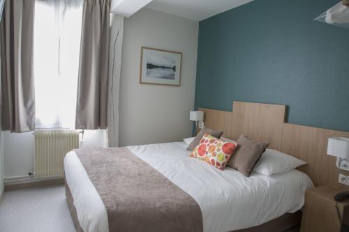 a bedroom with a large bed with two pillows at Logis Hôtel Chaptal, Amboise in Amboise