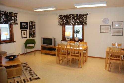 a living room with a table and a television at Storstrand Kursgård in Piteå