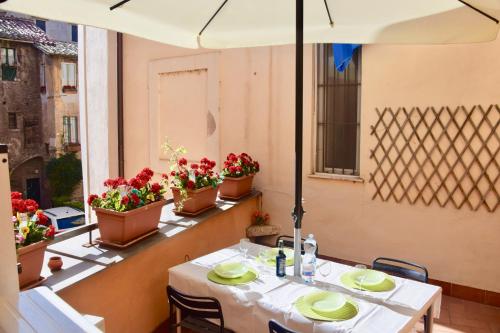 a restaurant with two tables and flowers on a balcony at Cuore di Roma Apartment in Rome