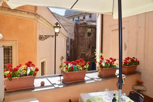 ローマにあるCuore di Roma Apartmentの窓際の鉢植えの花が飾られたバルコニー