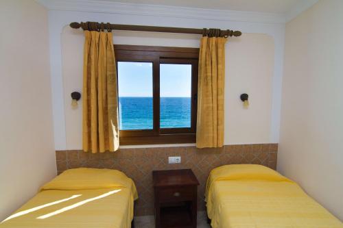 ネルハにあるCARABEO 72 MENYBERのベッド2台、海の景色を望む窓が備わる客室です。