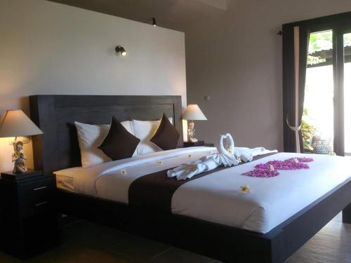 a bedroom with a large bed with flowers on it at Pandawa Village in Lovina