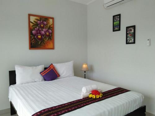 a bedroom with a white bed with flowers on it at CF Komodo Hotel in Labuan Bajo