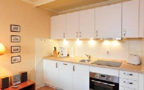 韋斯特蘭的住宿－Appartement-Makrele，厨房配有白色橱柜和水槽