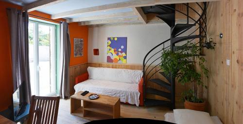 um pequeno quarto com uma cama e uma mesa em L'Atelier d'Aubiac em Aubiac
