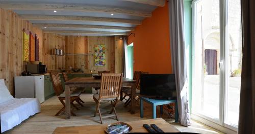 uma sala de estar com mesa e cadeiras e uma cozinha em L'Atelier d'Aubiac em Aubiac