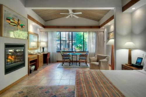 a bedroom with a bed and a table and chairs at Dinah's Garden Hotel in Palo Alto