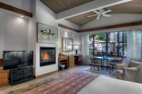 a living room with a television and a fireplace at Dinah's Garden Hotel in Palo Alto